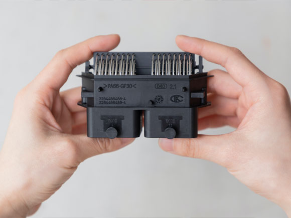 Close-up of the connector held in hand with the company logo